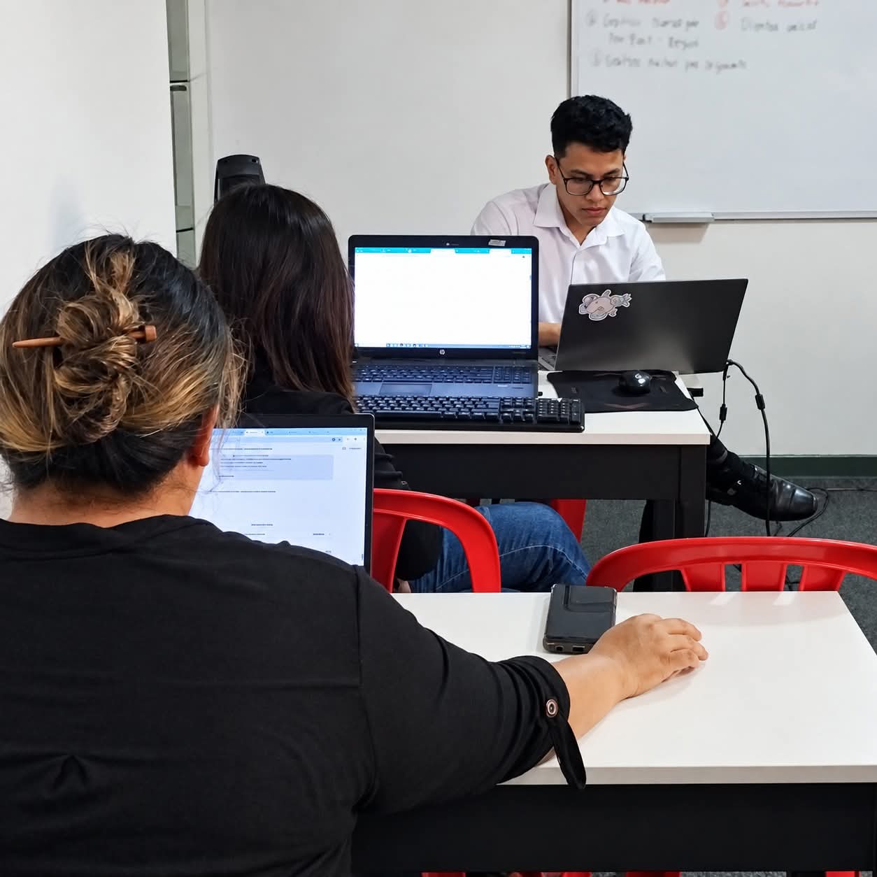Docente de INTEC explicando contenido en pantalla durante una clase